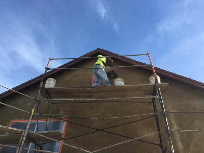 Color coat being applied over existing stucco (right under the eaves).